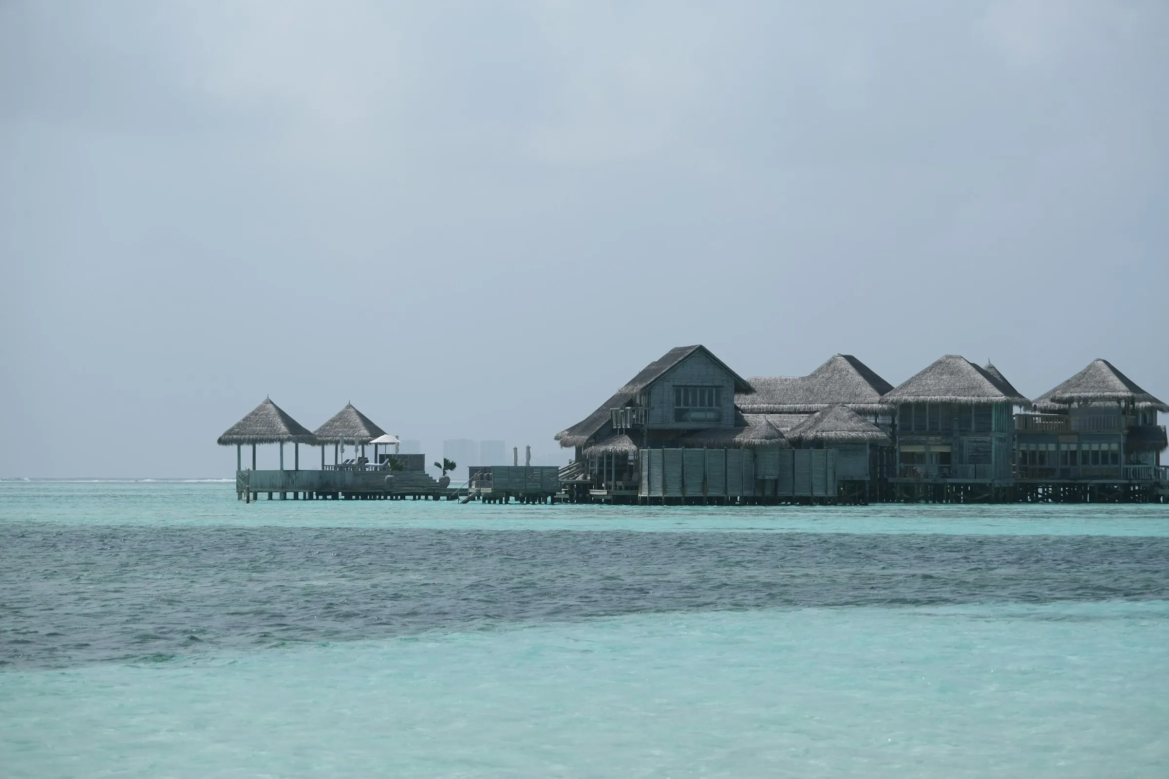 Overwater bungalows on clear turquoise water